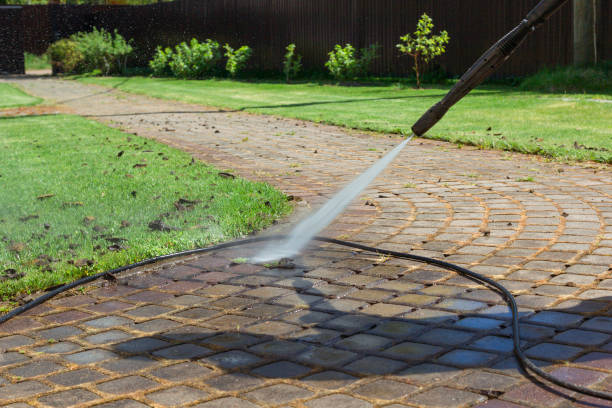 Cleaning street with high pressure power washer, washing stone garden paths stock photo