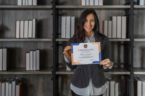 business portrait of caucasian business woman posing with certificate of appreciation recieved from business performace competition award winning stock photo