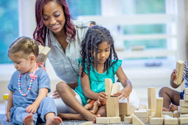 istock Preschool teacher playing with blocks with her students 1302192958