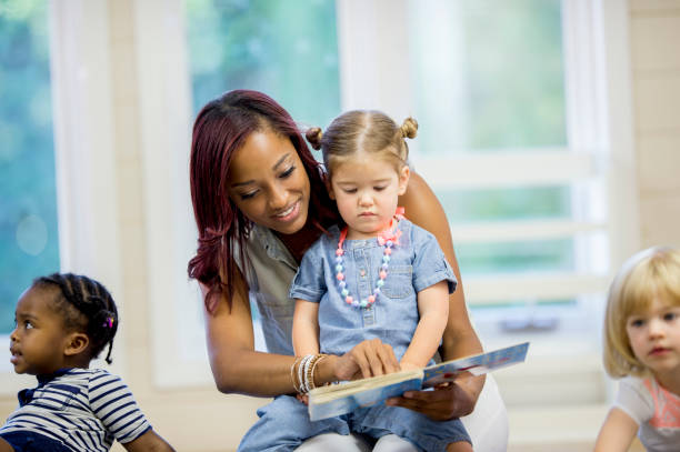istock Preschool teacher reading a book to her student 1302192971