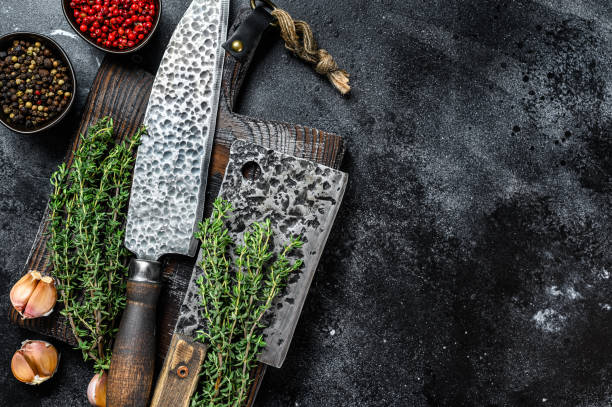 istock Chopping board and meat cleaver with knife. Black background. Top view. Copy space 1302194639