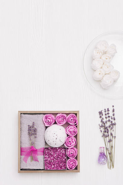 istock Spa still life composition with items for body care with lavender aroma. Personal gift box from sea salt, bath roses, bomb, towel, lilac dry flowers. 1302194840