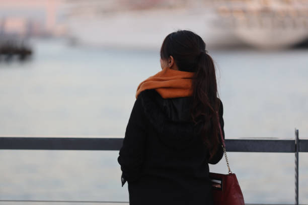 istock Beautiful young woman looking ship in harbour 1302195770