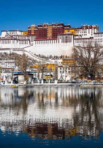 Photo of Stunning view and reflection of the famous Potala Palace in the heart of Lhasa in Tibet province in China on a sunny winter day.