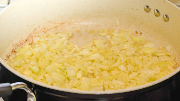 istock Fried chopped onion on frying pan, close up cooking process, recipe 1302202655