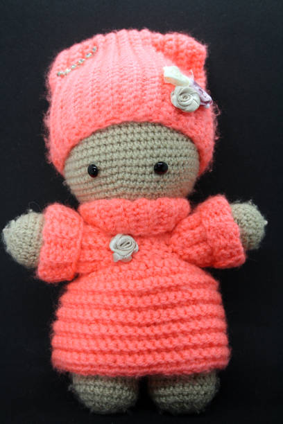istock A doll made of yarn on a black background. 1302203820