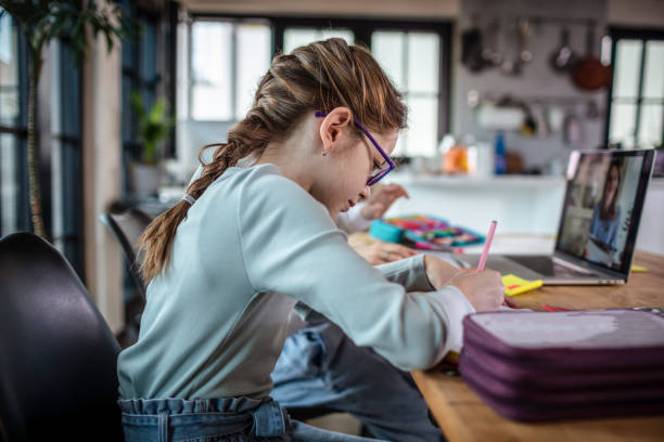 istock Girls attending online school class 1302209409