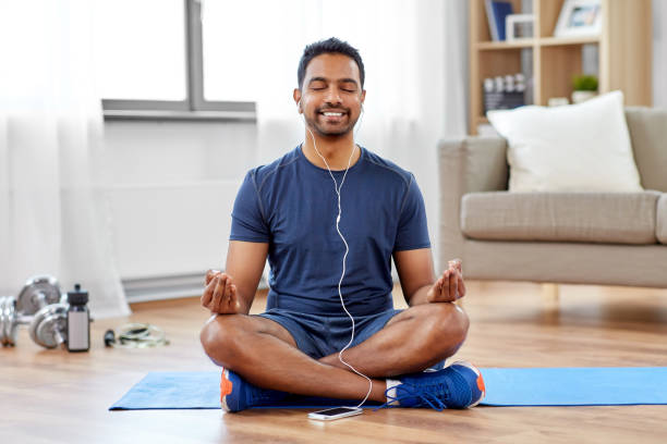 istock indian man meditating in lotus pose at home 1302210764