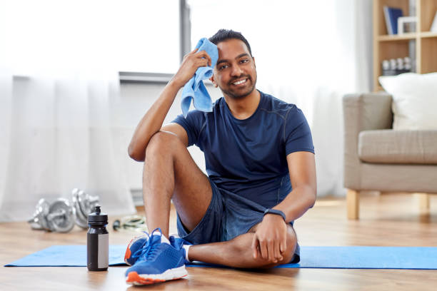 istock tired indian man with towel after training at home 1302211431