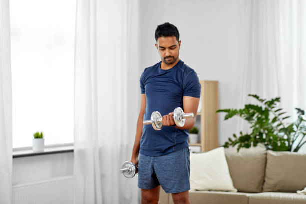 istock indian man exercising with dumbbells at home 1302211443