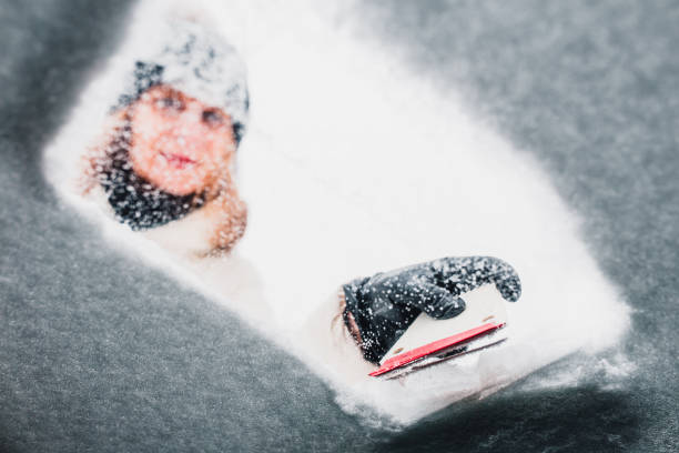 女性はフロントガラスから氷を取り除く - snow car window ice scraper ストックフォトと画像