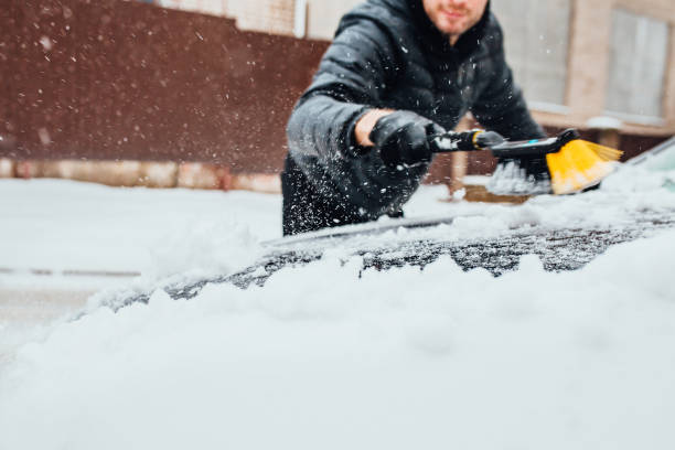 człowiek szczotkowanie szczotki samochodowej ze śniegu w zimie w godzinach porannych - snow car window ice scraper zdjęcia i obrazy z banku zdjęć