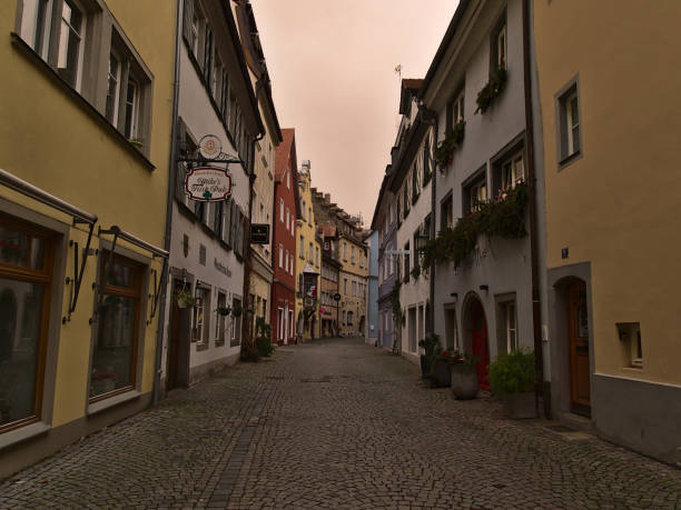 pusta aleja ze starymi budynkami w centrum miasta w pochmurny zimowy dzień. pomarańczowe niebo z powodu zjawiska pogodowego (sahara desert sand in air). - narrow alley zdjęcia i obrazy z banku zdjęć