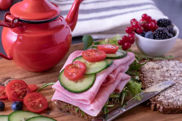 healthy fitness meal with wholemeal sandwich and fresh berries on a table. colorful image