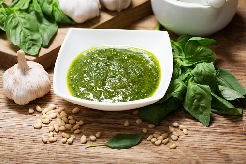pesto sauce with ingredients for cooking on a wooden table