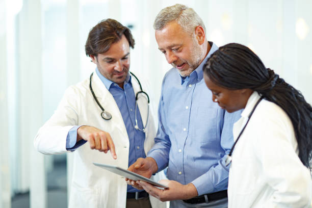 istock Businessman and doctors using touchpad at doctor's office. 1302223223