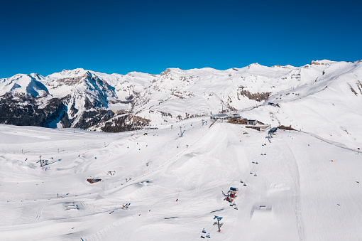 Aerial view of the Crans-montana ski resort with the snowpark and chair lift on a sunny winter day in the alps in Valais, Switzerland
