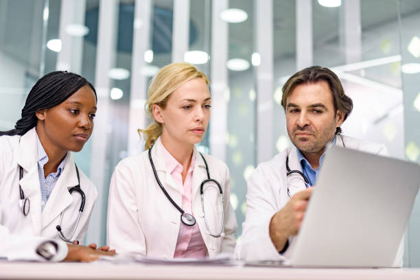 istock Group of doctors working on laptop in the office. 1302223473