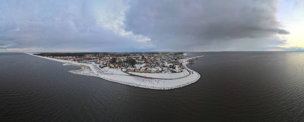 istock snow covered beach during wnter by Urk lighthouse in the Netherlands 1302223612