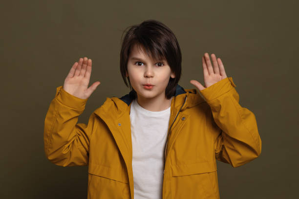 istock Emotional little boy express overjoy and surprised, spread hands sideways and smiling, showing astonishment and shock 1302223803