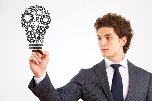 Businessman drawing light bulb made of gears for new business and strategies