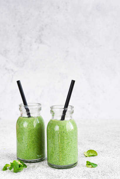 istock Detox menu. Smoothie with spinach on a concrete background in a jar. 1302226184