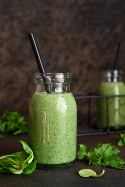 Detox menu. Vegetable smoothie with spinach on a dark concrete background in a jar.