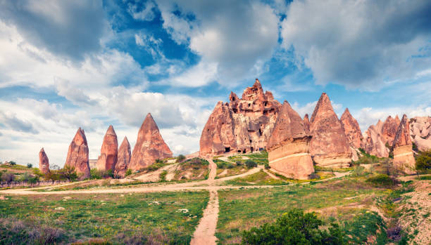 grande cena de primavera da capadócia. vista matinal pitoresca do vale da rosa vermelha em abril. aldeia cavusin localizada, distrito de nevsehir, turquia, ásia. histórico de conceito de viagem. - goreme rural scene sandstone color image - fotografias e filmes do acervo