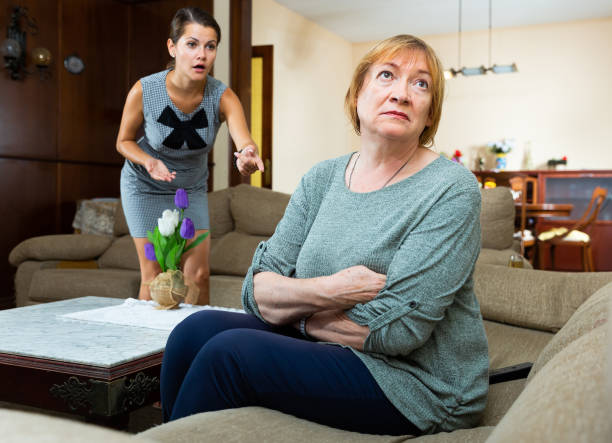 elderly mother and adult daughter scandal in domestic interior - unwillingness imagens e fotografias de stock