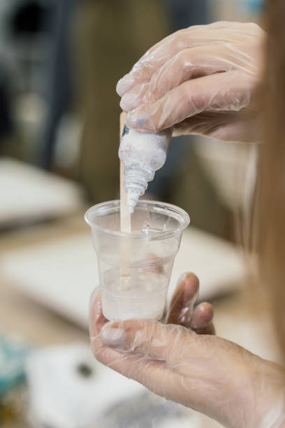 istock work on a workshop to create resin art. small glass with white resin 1302231173