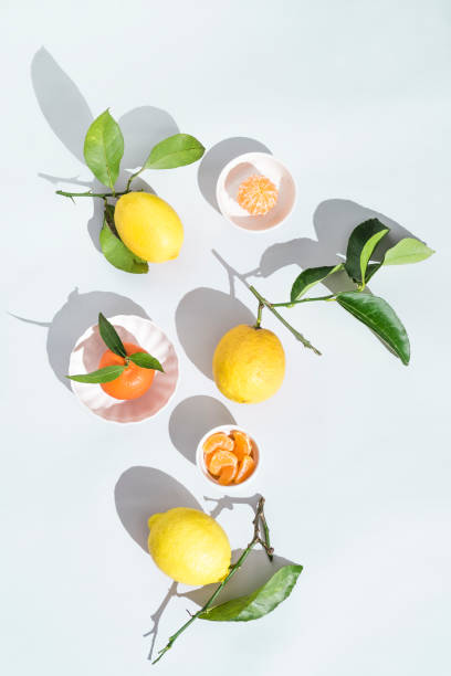 istock Summer still life with citrus tangerines and lemons on a white background, bright sunlight 1302231940