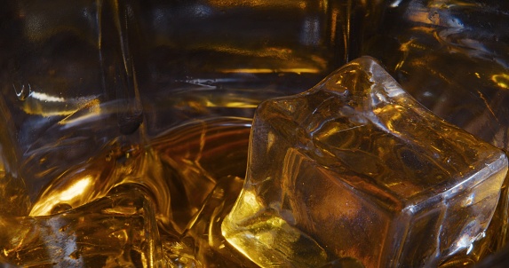 Scotch whiskey on the rocks. Close-up on the dark background