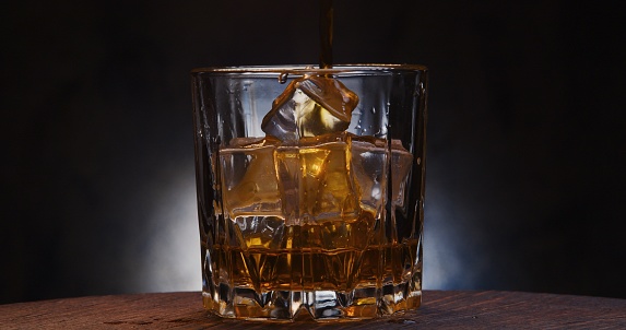 Scotch whiskey on the rocks. Close-up on the dark background