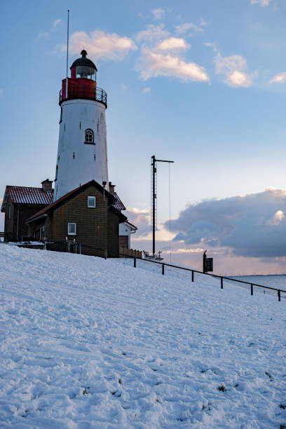 istock snow covered beach during wnter by Urk lighthouse in the Netherlands 1302235997