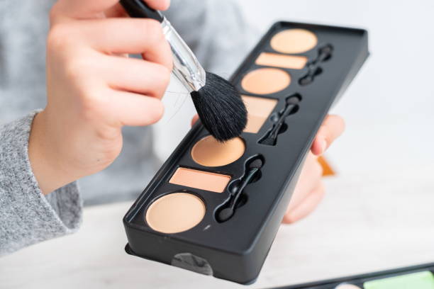 istock Woman doing doing cosmetic makeup tutorial blog with makeup paints sharing them on social media live internet online 1302237452