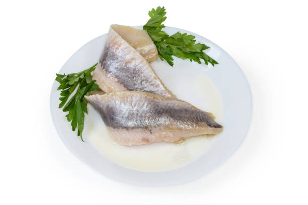 istock Pickled herring fillets on dish with fresh parsley 1302238875