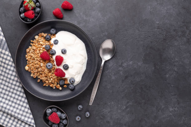 Healthy breakfast with baked granola and greek yogurt. Assorted fresh berries