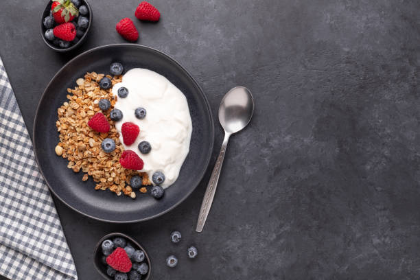 Healthy breakfast with baked granola and greek yogurt. Assorted fresh berries stock photo