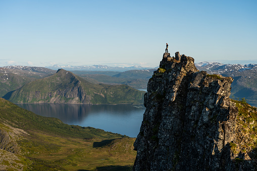 A man hiker and traveller standing on top of Husfjellet in Senja island in summer season, Norway, Scandinavia, Europe