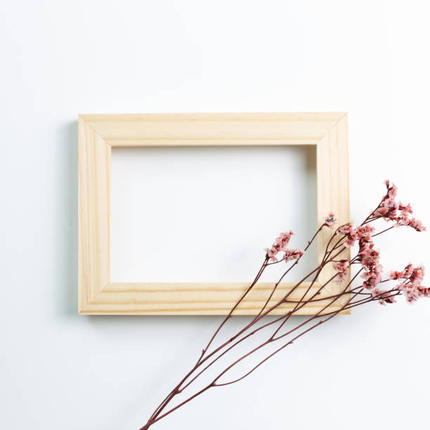 istock Empty photo frame with red sinensis dry flower on white background. flat lay, top view, copy space 1302246161