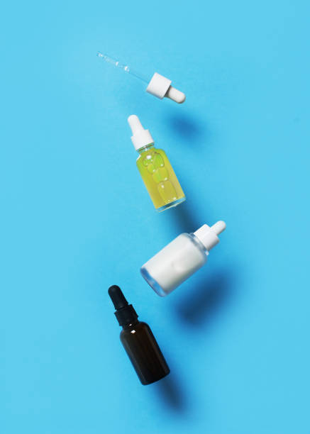 istock Beauty levitation concept with serum bottles on blue background, 1302248601