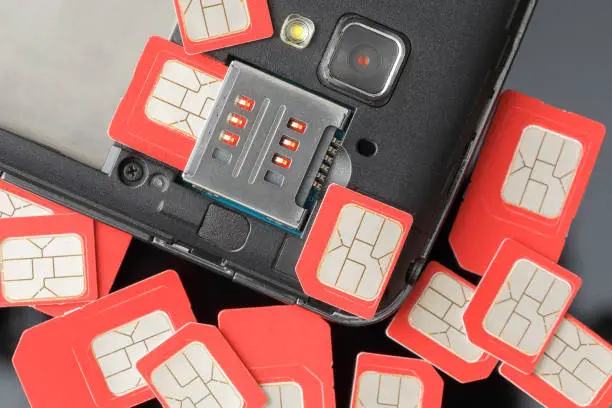 Cell phone and many red sim cards, closeup