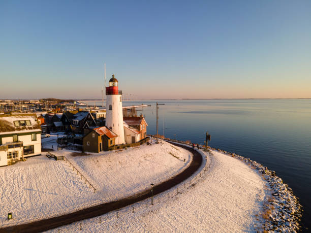 istock snow covered beach during wnter by Urk lighthouse in the Netherlands 1302248888