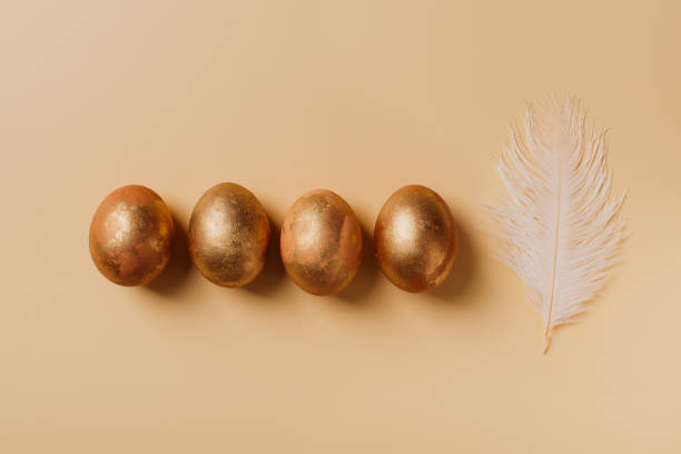 istock Golden egg with feather, easter concept, flat lay, on yellow background 1302249259