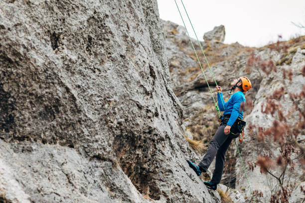 istock Focused climber observing cliff ascent, while planning his safety route to the top 1302250661