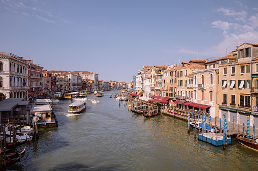 Venice, Italy - July 1, 2018: Panoramic view of Grand Canal (Canal Grande) from Rialto Bridge. It is a major water-traffic corridors in Venice city. Landscape of summer sunny day and blue sky