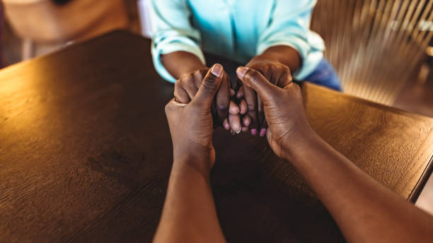 Put love first Photo of a man and woman holding hands at a table clingy girlfriend stock pictures, royalty-free photos & images