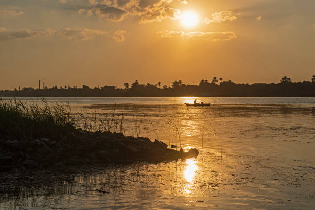 istock River bank silhouette at dusk sunset 1302251904