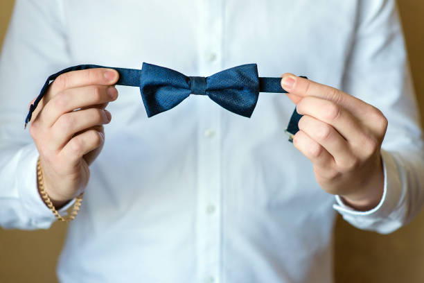 istock A man in a white shirt holds a bow tie 1302252591