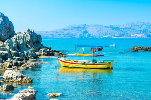 Sun shinning on a windy day. Traveling sailing boat on water surface. Natural sunlight shimmering and reflecting over sea background with large copy space. Amazing aqua view. Summer vacation. Island silhouettes in distance